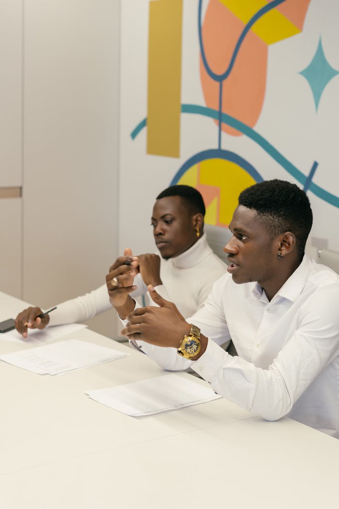 Two professionals collaborating in a modern office setting, discussing over papers.