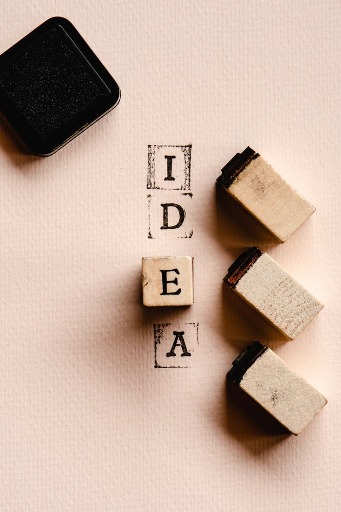 services-02 Artistic flat lay of wooden blocks spelling 'IDEA' with ink pad, perfect for DIY inspiration.