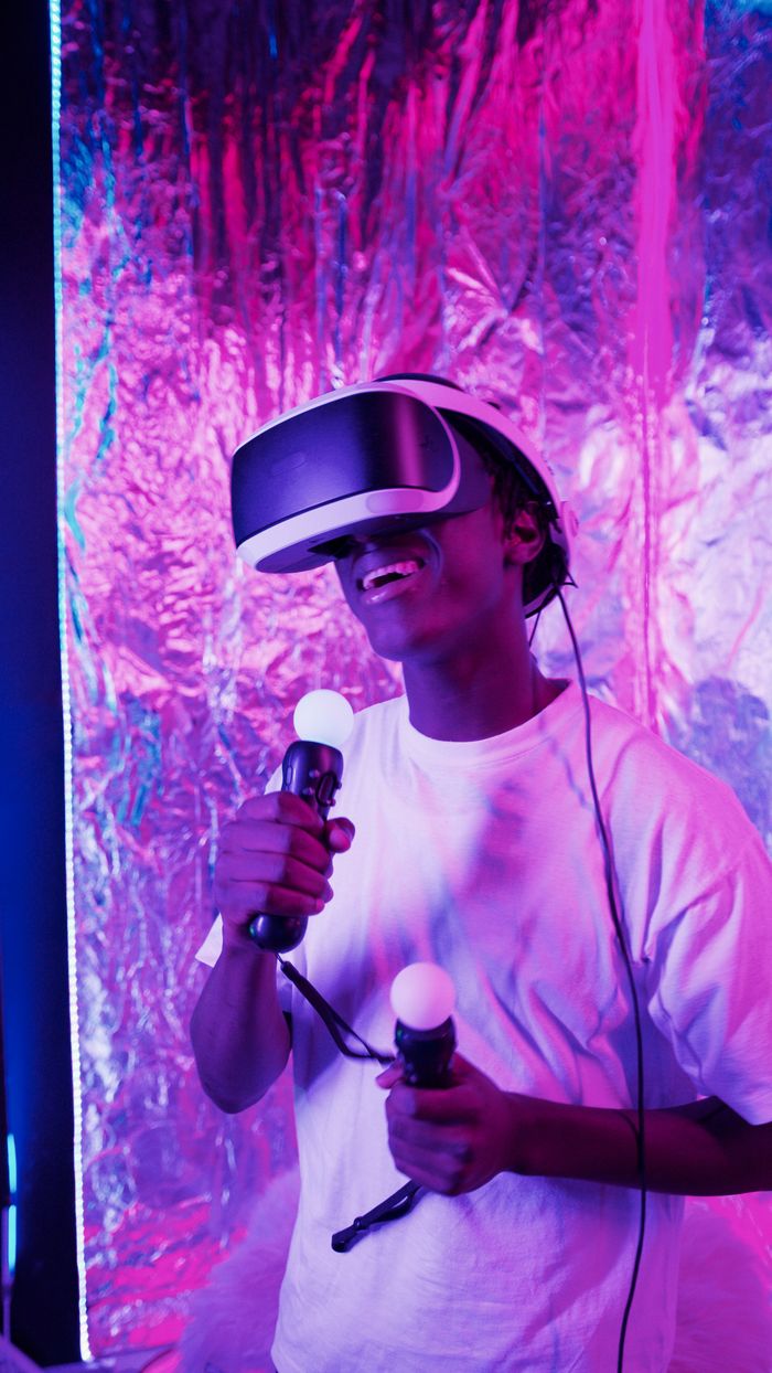 services-01 A young man immersed in a virtual reality experience with vibrant neon lights.